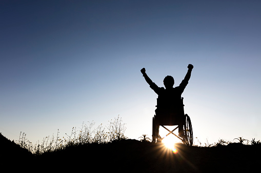 fauteuil heureux victoire bras levés soleil